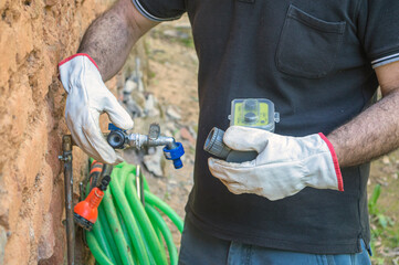 Operator installing a water pressure regulator on a tap, Spain, Andalusia