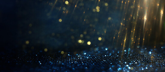 background of abstract glitter lights. gold, blue and black. de focused