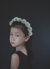 Portrait Of Girl Wearing Dandelion Fluffs Headband Standing Indoors
