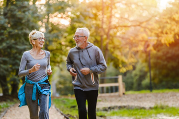 Smiling senior couple jogging in the park