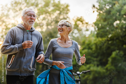 Fotografía Smiling senior couple jogging in the park