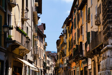 Wall Mural - Close up view on the old Italian street with historic traditional houses in Brescia, Lombardy, Italy. European architecture and landmark with wooden windows, shutters, chimneys, tiled roofs.