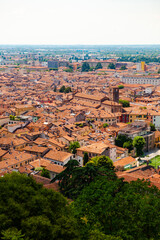 Wall Mural - Aerial view of the historical center of Brescia (Lombardy, Italy) with tiled red roofs, chimneys, cathedral's domes and tall white brick old towers. Traditional European medieval architecture. 