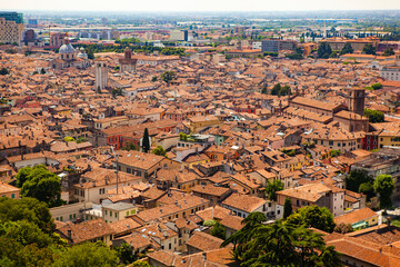 Wall Mural - Aerial view of the historical center of Brescia (Lombardy, Italy) with tiled red roofs, chimneys, cathedral's domes and tall white brick old towers. Traditional European medieval architecture. 