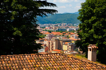 Wall Mural - Aerial view of the historical center of Brescia (Lombardy, Italy) with tiled red roofs, chimneys, cathedral's domes and tall white brick old towers. Traditional European medieval architecture. 