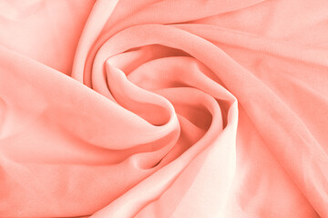 Coral pink delicate fabric draped and spun. Closeup.