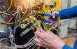 © romaset - Network engineer working in server room. Connecting network cables to switches