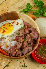 Wall Mural - Dish with meat, rice and omelet served in a wooden bowl and some vegetables nearby