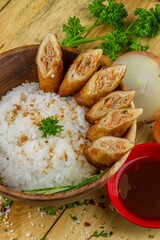 Sticker - Dish of rice with cut rolls and cucumber served in a bowl with sauce and onion nearby