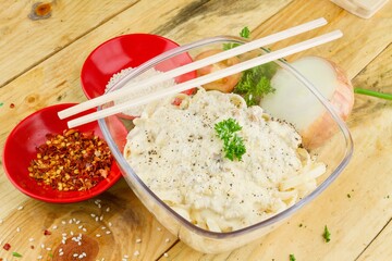 Poster - Bowl of spaghetti with parmesan on top and some garnishes in red plates nearby