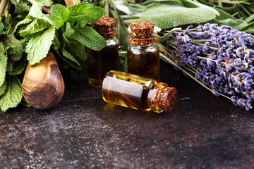 Wall Mural - Fresh herbs from the garden and the different types of oils for massage and aromatherapy on table with lavender