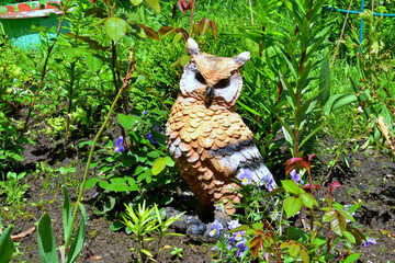 figurine of an owl in a flower bed