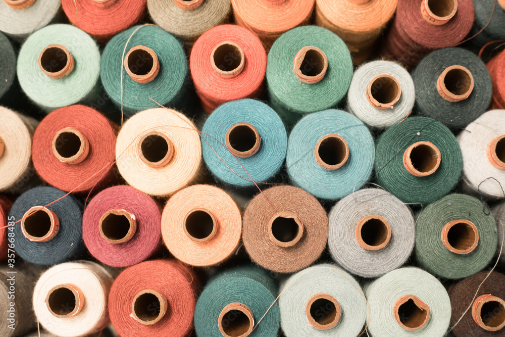 Threads in a tailor textile fabric: colorful cotton threads, birds eye perspective - obrazy, fototapety, plakaty 