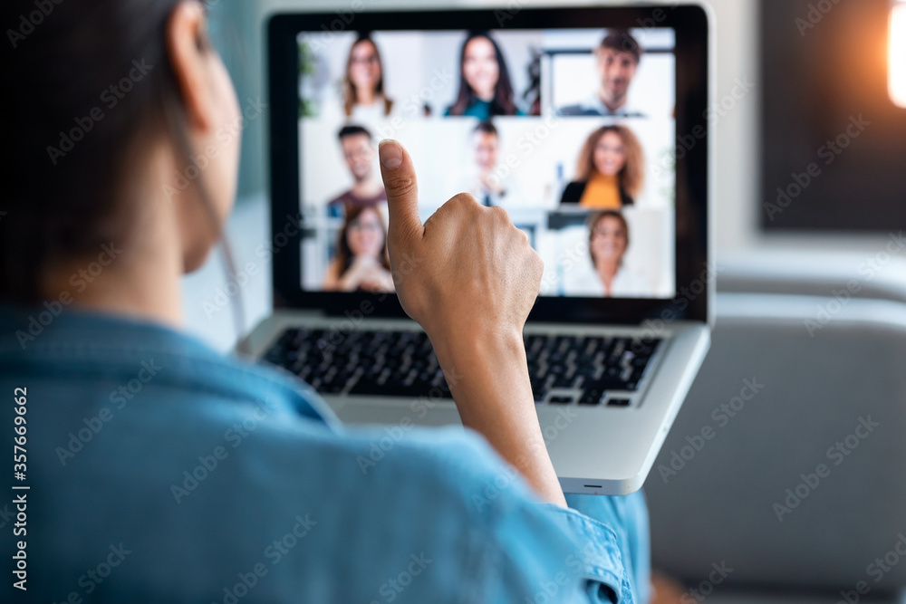 Business woman making video call and showing thumb up to laptop on the online briefing while sit on sofa at home. - obrazy, fototapety, plakaty 