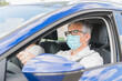 © Tomaspf_ - New normal. Driver with a medical face mask driving a car with a passenger. Health protection. Family in the car protected by a mask safety and pandemic concept. Coronavirus devices. Social distance.
