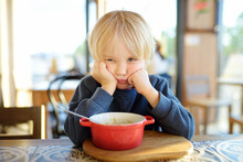 Little Child Sitting The Table In Cafe Or Restaurant And Doesn't Want To Eat. Healthy Food. Kids Diet. Poor Appetite.