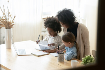 african mom of two multiethnic school age daughters do lesson homework helps them. american and cauc