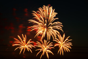 Festive fireworks in the night sky. Bright multi-colored salute on a black background. Place for text.