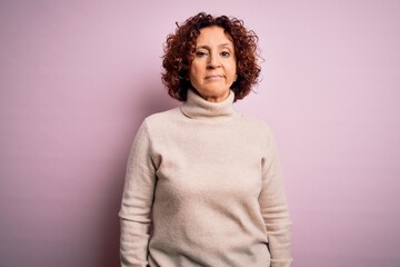 Canvas Print - Middle age beautiful curly hair woman wearing casual turtleneck sweater over pink background looking sleepy and tired, exhausted for fatigue and hangover, lazy eyes in the morning.