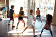 © Svitlana - Kids working out using resistance band in gym together with female trainer. Sport, healthy lifestyle, physical education concept