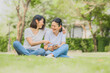© interstid - Asian women laughing while using smartphone outdoor