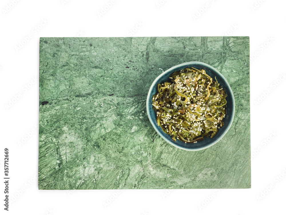 Bowl with tasty seaweed on white background