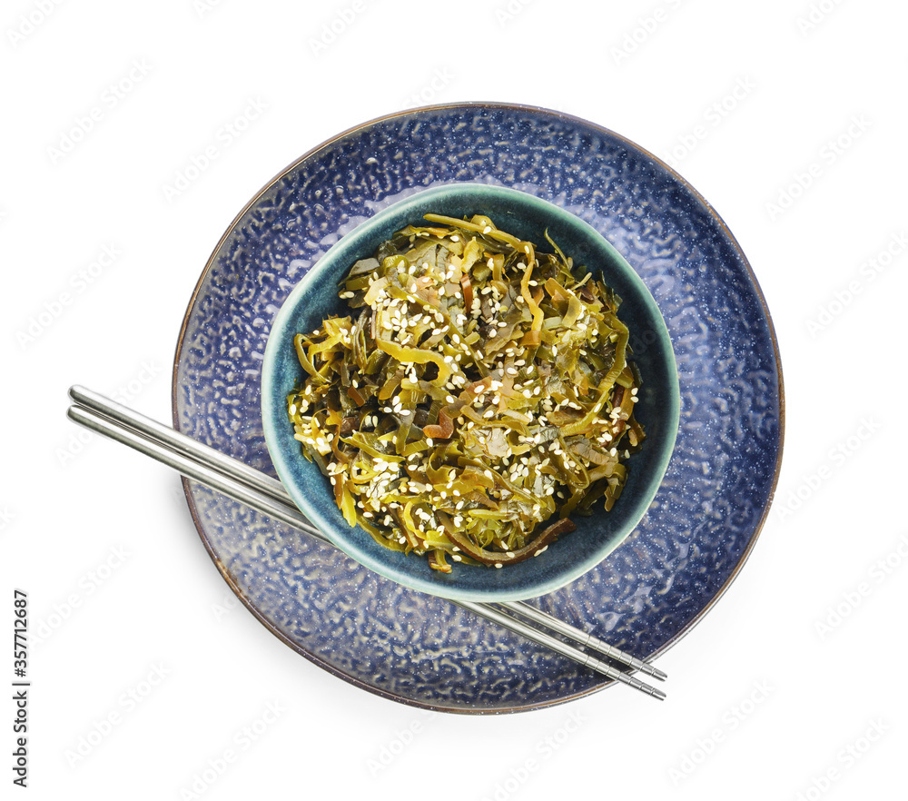 Bowl with tasty seaweed and chopsticks on white background