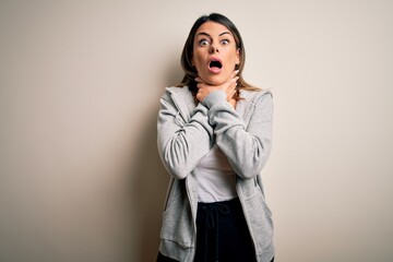 Sticker - Young beautiful brunette sportswoman wearing sportswoman training over white background shouting and suffocate because painful strangle. Health problem. Asphyxiate and suicide concept.