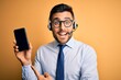 © Krakenimages.com - Business operator man with customer service headset from call center showing smartphone screen very happy pointing with hand and finger