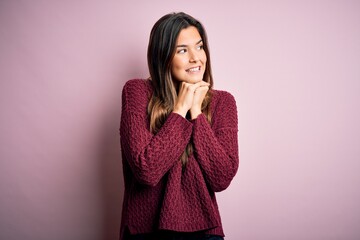 Poster - Young beautiful girl wearing casual sweater over isolated pink background laughing nervous and excited with hands on chin looking to the side