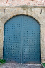 Sticker - Vertical shot of an old blue gate in an ancient building during daytime