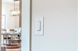 © Jason - Wall mounted electrical rocker light switch with blurry dining room background