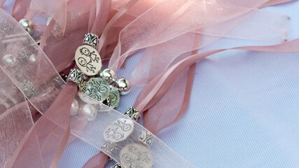 Sticker - Closeup shot of pink ribbons with different silver charms