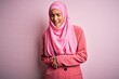 © Krakenimages.com - Young beautiful brunette businesswoman wearing pink muslim hijab and business jacket with hand on stomach because nausea, painful disease feeling unwell. Ache concept.