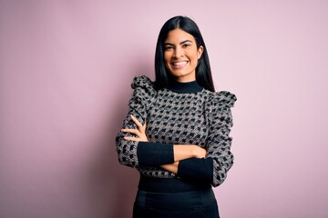 Young beautiful hispanic business woman wearing elegant sweater over pink background happy face smiling with crossed arms looking at the camera. Positive person.