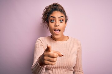 Canvas Print - Young beautiful african american girl wearing casual sweater standing over pink background pointing displeased and frustrated to the camera, angry and furious with you