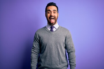 Poster - Handsome businessman with beard wearing casual tie standing over purple background sticking tongue out happy with funny expression. Emotion concept.