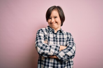 Poster - Young down syndrome woman wearing casual shirt over pink background happy face smiling with crossed arms looking at the camera. Positive person.