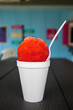 A vibrant red cherry snowball or snocone shaved ice summer treat or dessert