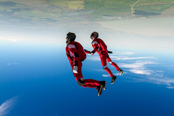 Two sports parachutist build a figure in free fall. Extreme sport concept.