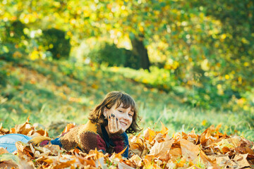 Wall Mural - Close up portrait of smiling young pretty girl in the fall time. Autumn leave. Closeup. The colors and mood of autumn. Autumn yellow leave.