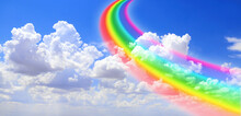 White Clouds In The Blue Sky And Colourful Rainbow