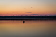 © were - Fishermen in a rowing boat on the lake at sunset