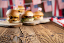 Fourth Of July Celebration. American Flag And Decorations. Burgers On Rustic Wooden Table.