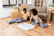 © Syda Productions - mortgage, people and real estate concept - happy african american couple with boxes and blueprint moving to new home