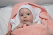 © Andrej - Baby lying on back under the pink towel after bath. Four months old baby girl.