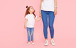 © oes - Family values. Mom and daughter in white t-shirts and jeans play and hug on a pink background. Caring for loved ones. Happy motherhood