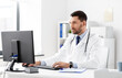 © Syda Productions - healthcare, medicine and people concept - male doctor with computer working at hospital
