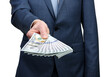 © Alekss - Businessman holding money cash in hands of passing them to the client.