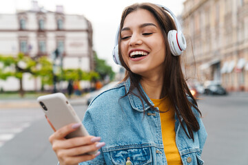 Image of woman listening music with smartphone and wireless headphones